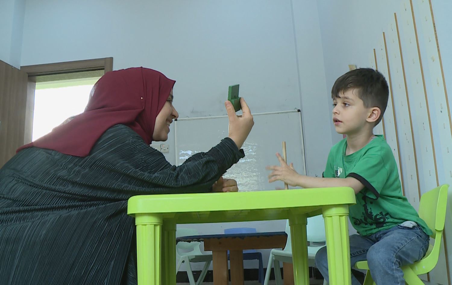 راهێنەرێک لە سەنتەرێکی ئۆتیزمی حکومی لە سلێمانی لەگەڵ منداڵێکی ئۆتیزم. وێنە: رووداو