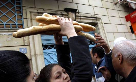 امرأة تأخذ رغفان خبز من أحد الأفران التونسية 