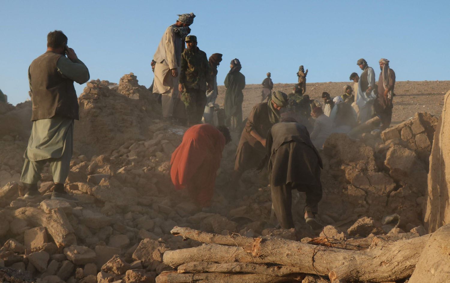 کۆمەڵێک خەڵک لەکاتی گەڕان بەدوای قوربانییان لەژێر داروپەردووی ماڵێکی رووخاودا بەهۆی بوومەلەرزەکە، وێنە: AFP