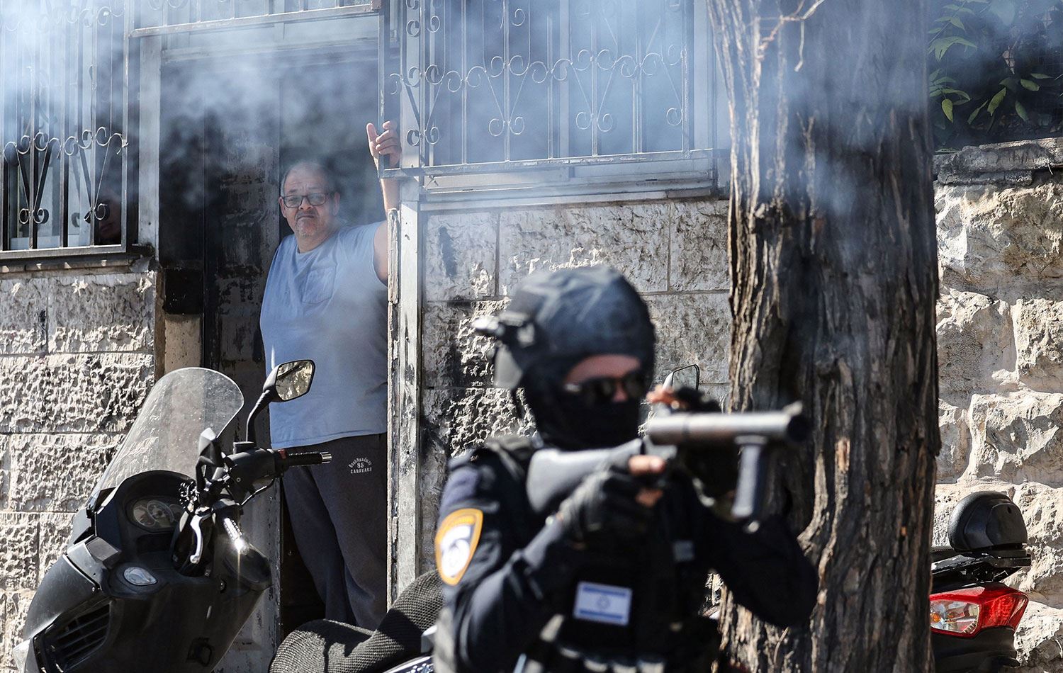 İsrail güvenlik güçleri üyeleri bugün doğu Kudüs'te Filistinli protestoculara karşı göz yaşartıcı gaz kullandı. / AFP