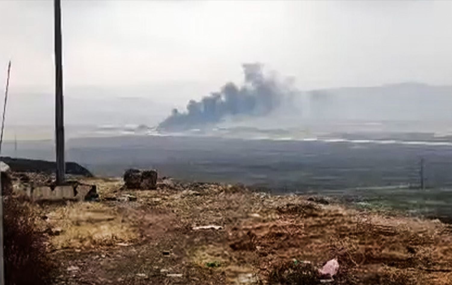 وێنەیەکی ئەرشیڤیی بەرزبوونەوەی دووکەڵ لە فڕۆکەخانەی سەربازیی هەریر لەدوای هێرشێکی درۆنی 