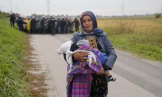 مهاجرة سورية وطفلها على الحدود بين سلوفينيا وكرواتيا في 2015/ Reuters