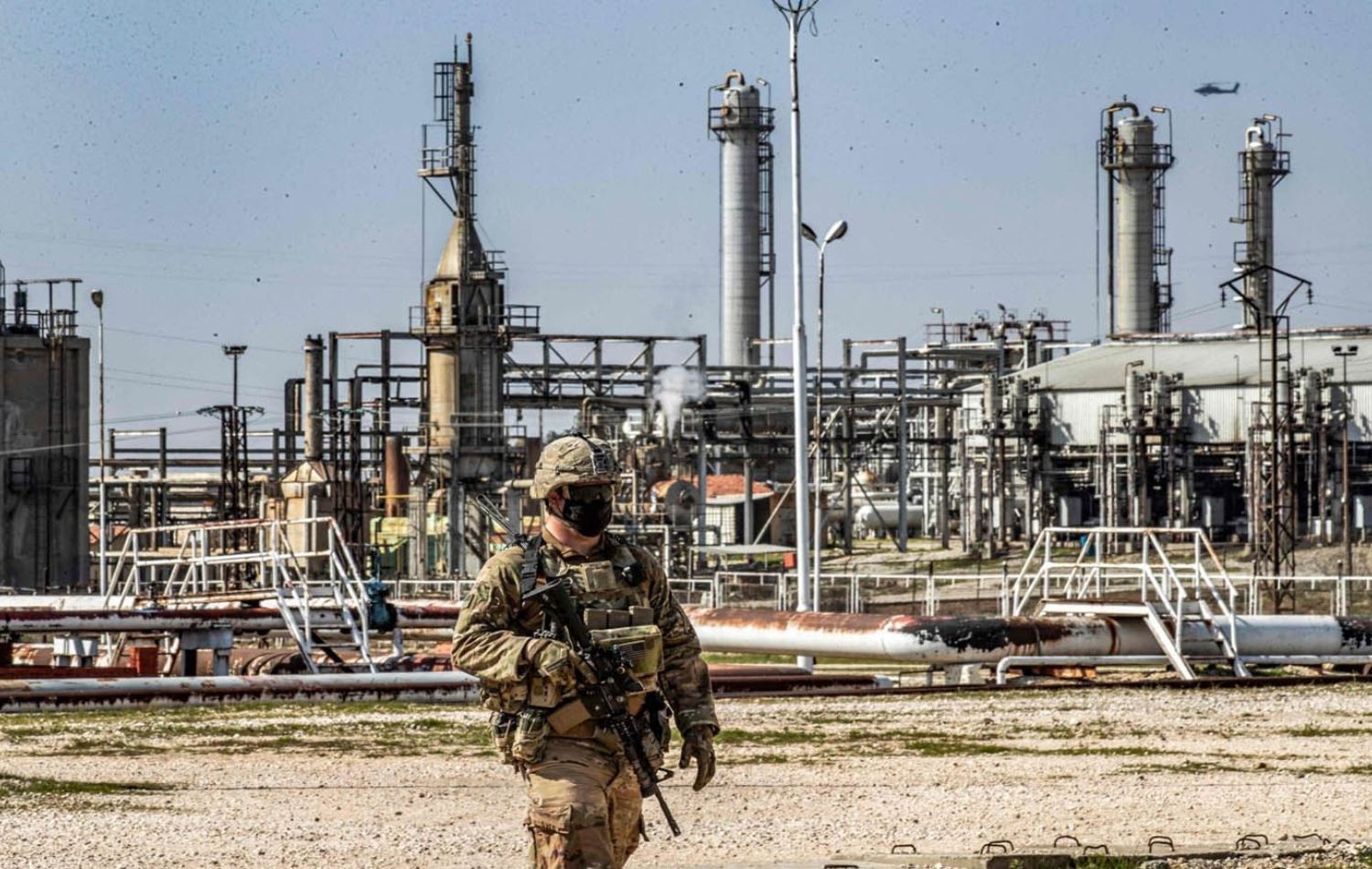  وێنەیەکی ئەرشیڤیی سەربازێکی ئەمریکی لەبەردەم بیرەنەوتەکانی سووەیدییە لە حەسەکەی رۆژئاوای کوردستان، وێنە: AFP