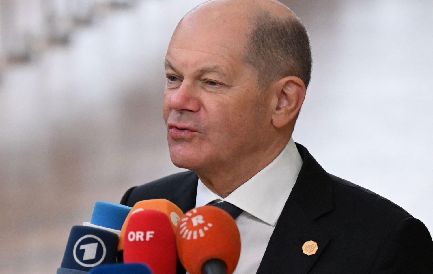  ئۆلاف شۆڵز، راوێژکاری ئەڵمانیا پێش دەستپێکردنی کۆبوونەوەکە قسە بۆ رۆژنامەڤانان دەکات، مایکی رووداویش لەبەردەمییەتی، وێنە: JOHN THYS / AFP