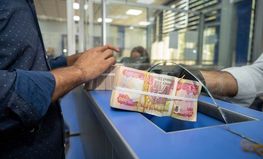 A person receives money from a bank. Photo: Rudaw/file 