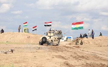 Iraqi army vehicles pass through Peshmerga forces on their way to the Makhmour front. File Photo: Rudaw