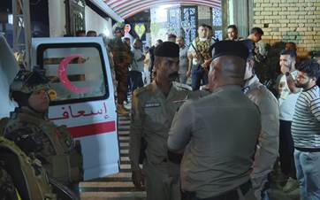 Security forces guard the entrance of the crime scene as an ambulance awaits the arrival of dead bodies after a man killed twelve family members and committed suicide in Basra, Iraq on May 9, 2024. Photo: Rudaw