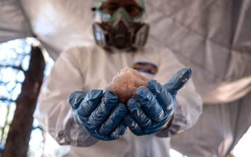 A Mexican Army expert in protective gear displays crystal methamphetamine seized from a clandestine laboratory in northwestern Mexico in August 2018. Photo: Guillermo Arias/AFP