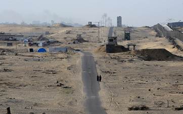 Two women walk on an asphalted road in the middle of a deserted camp for displaced Palestinians on the border with Egypt in Rafah in the southern Gaza Strip on May 22, 2024. Photo: Eyad Baba/AFP
