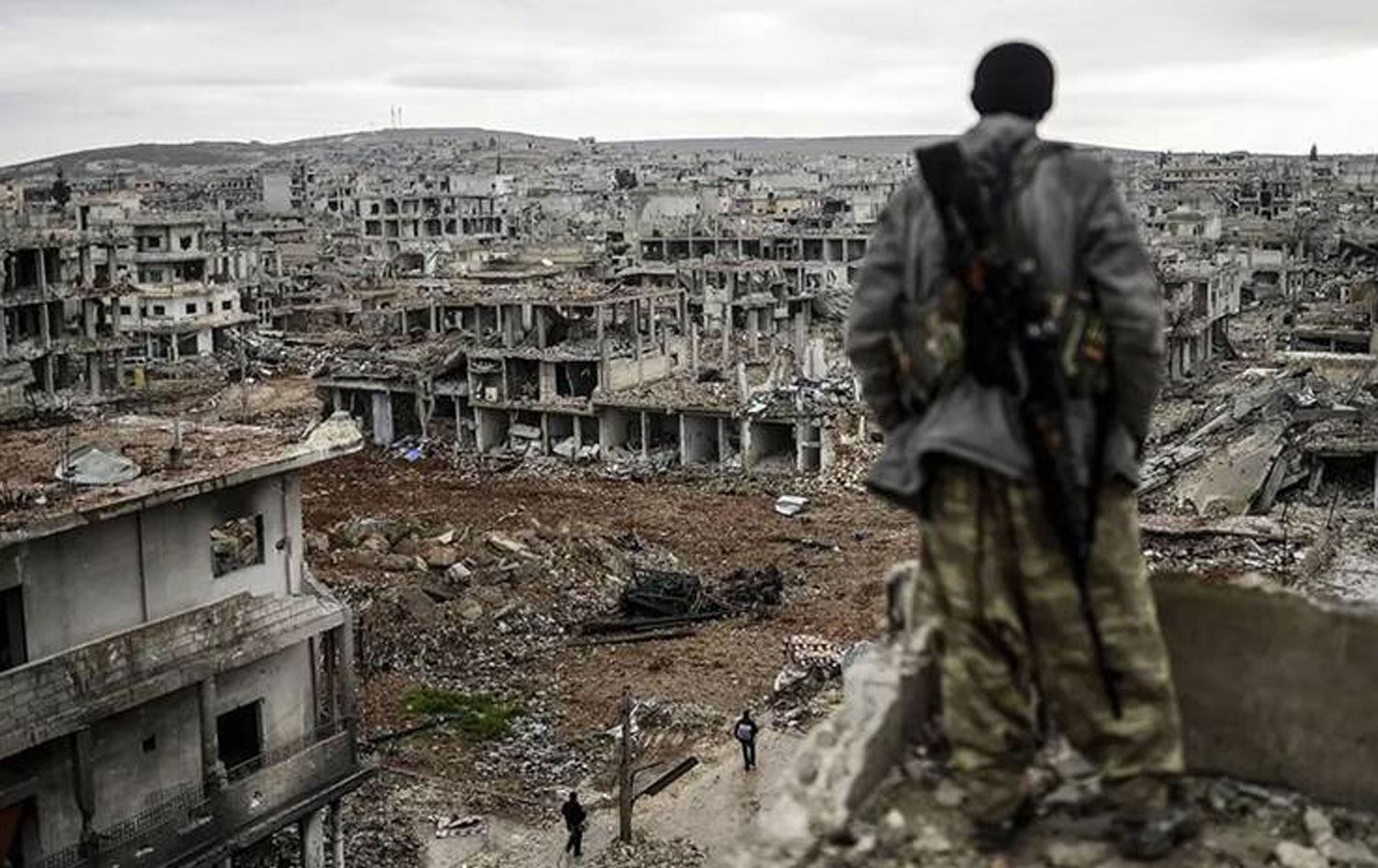 Şervanekî Kurd li bajarê wêranbûyî dimeyîzîne / Wêne: AFP-Arşîv