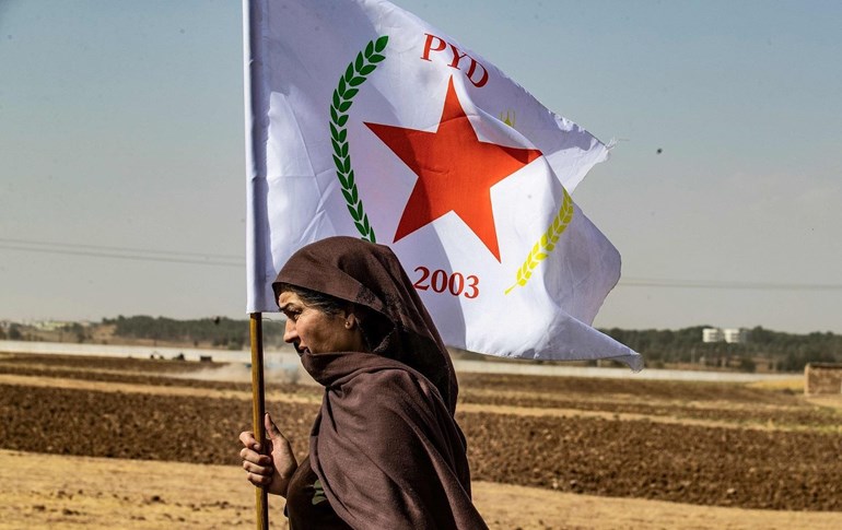 A Syrian Kurdish woman waves the flag of the Democratic Union Party (PYD) in Sari Kani (Ras al-Ayn), northern Syria, October 6, 2019. Photo: Delil Souleiman/AFP 