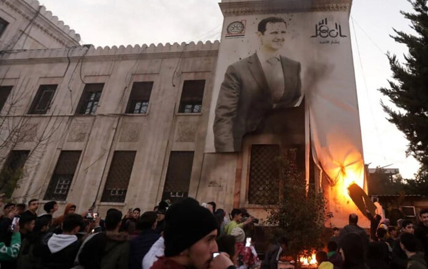 Rejimin düşüşü sonrası Esad'ın resmini kurşunlayan muhalifler / Foto: AFP