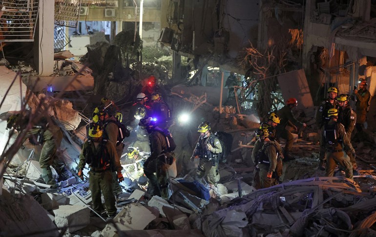 Responders search through building rubble following a strike by an Iranian missile in the Israeli city of Bat Yam, south of Tel Aviv, early on June 15, 2025. Photo: AFP