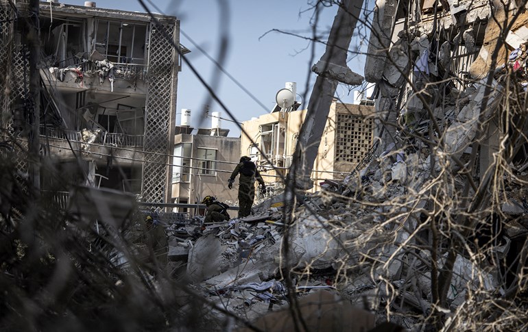 Israeli emergency responders search for victims amid the rubble of a damaged building following an overnight Iranian missile strike in Bat Yam on June 15, 2025. Photo: AFP