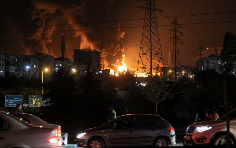 Vehicles jam a highway as a fire blazes nearby in the oil depots of Shahran, northwest of Tehran, on June 15, 2025. Photo: Atta Kenare/AFP