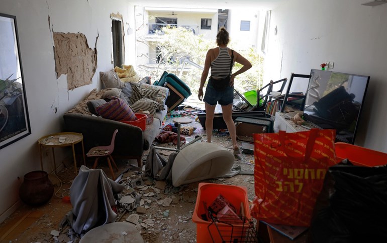 دوای هێرشی ئێران بۆ سەر شاری رامات ئەڤیڤ، کەسێک سەیری زیانی ماڵەکەی دەکات. وێنە: AFP