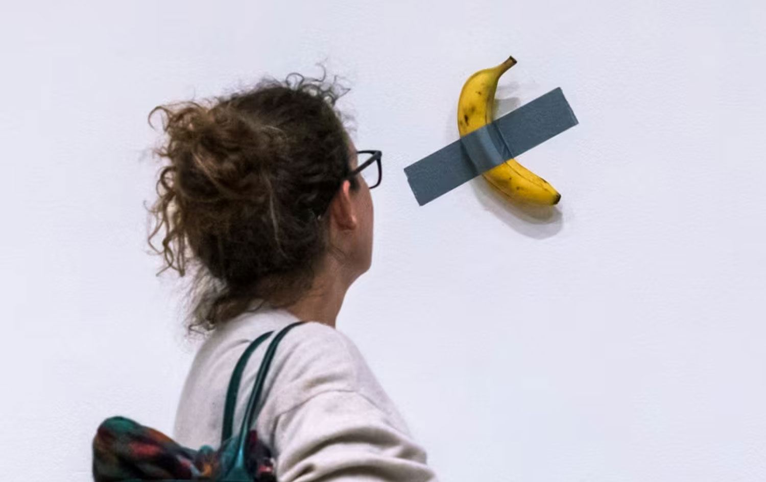 Jinek li muzeyeke li New Yorkê li berhema Maurizio Cattelan a bi navê Komedyen dinêre / Wêne: AP- Arşîv 