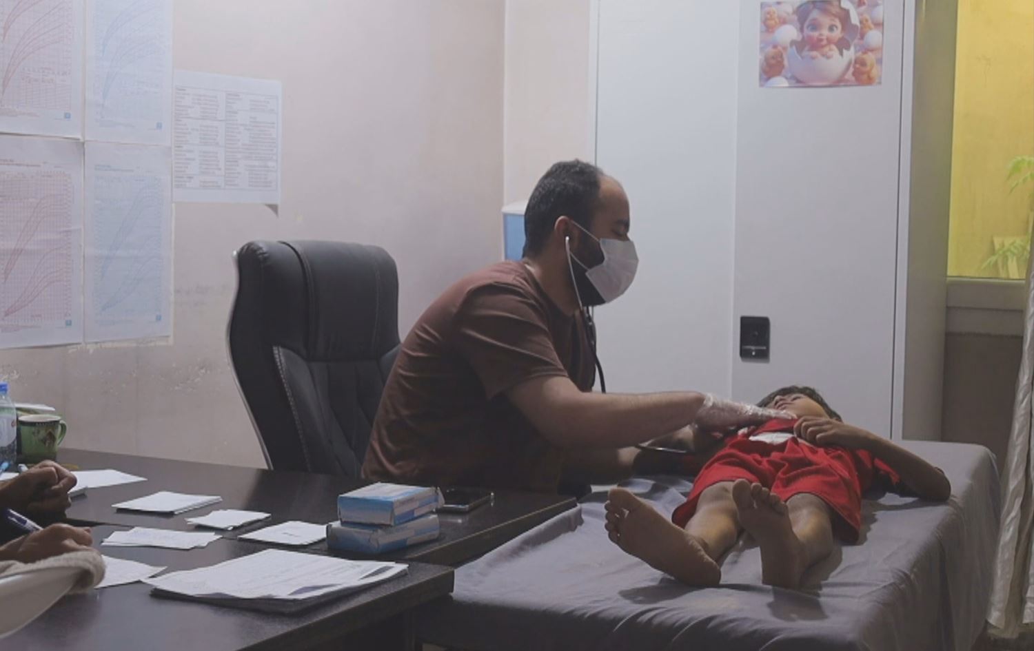 Bijîşk zarokekî derman dike / Wêne: Ji ber dîmenan