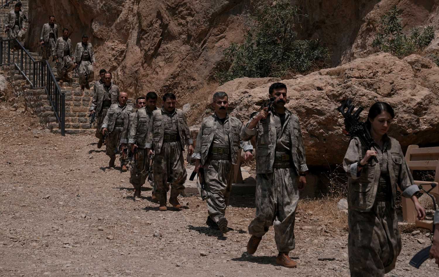 ژمارەیەک بەرپرس و گەریلای پەکەکە لەبەردەم ئەشکەوتی جاسەنە چەک دادەنێن. وێنە: AA