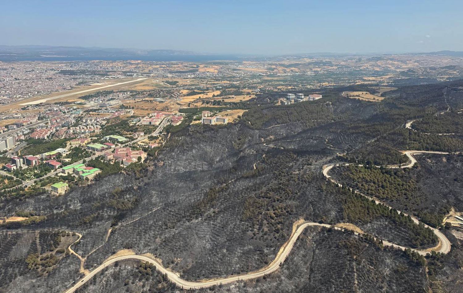 Yangından etkilenen ormanlık alan, helikopterden görüntülendi. Fotoğrafta kent merkezindeki yangından etkilenen alanlar görülüyor. / AA