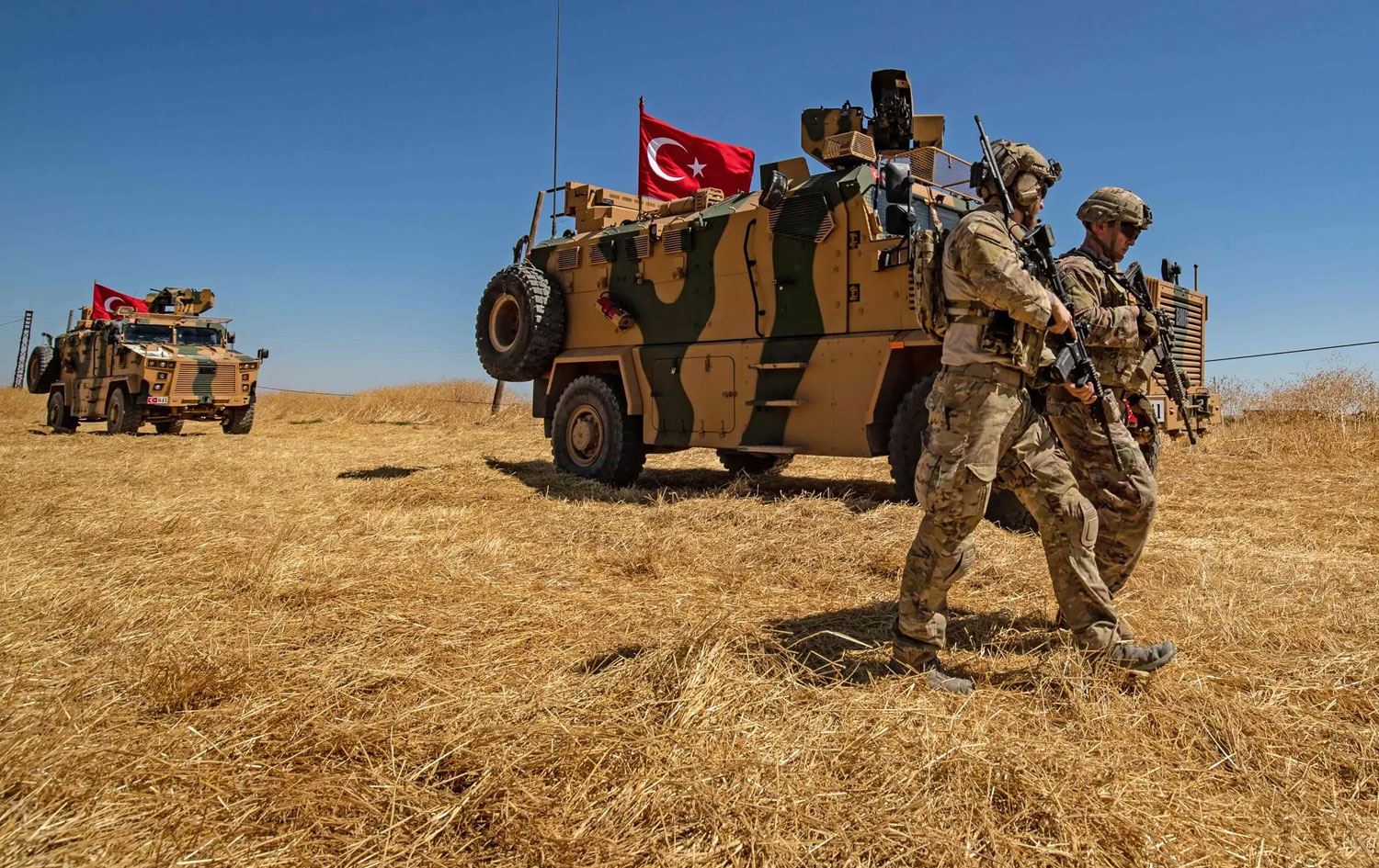 Leşkerên Amerîkayê li Girê Spî li kêleka wesayitên leşkerî yên Tirkiyeyê ne / Wêne: Delil Souleiman/AFP- Getty Images