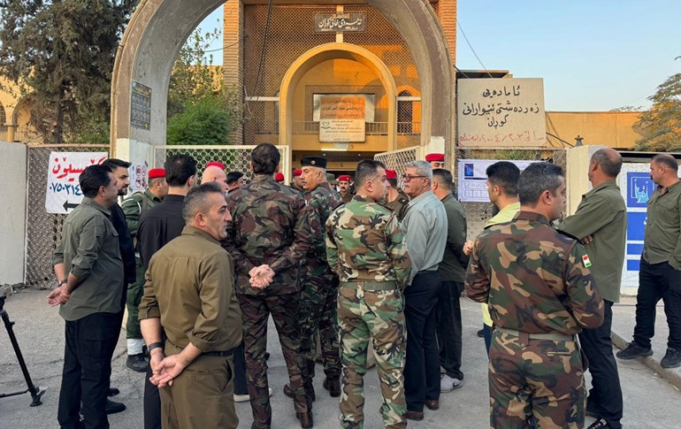 ژمارەیەک لە ئەندامانی هێزە ئەمنییەکان لەبەردەم بنکەیەکی دەنگدانی تایبەت. وێنە: رووداو