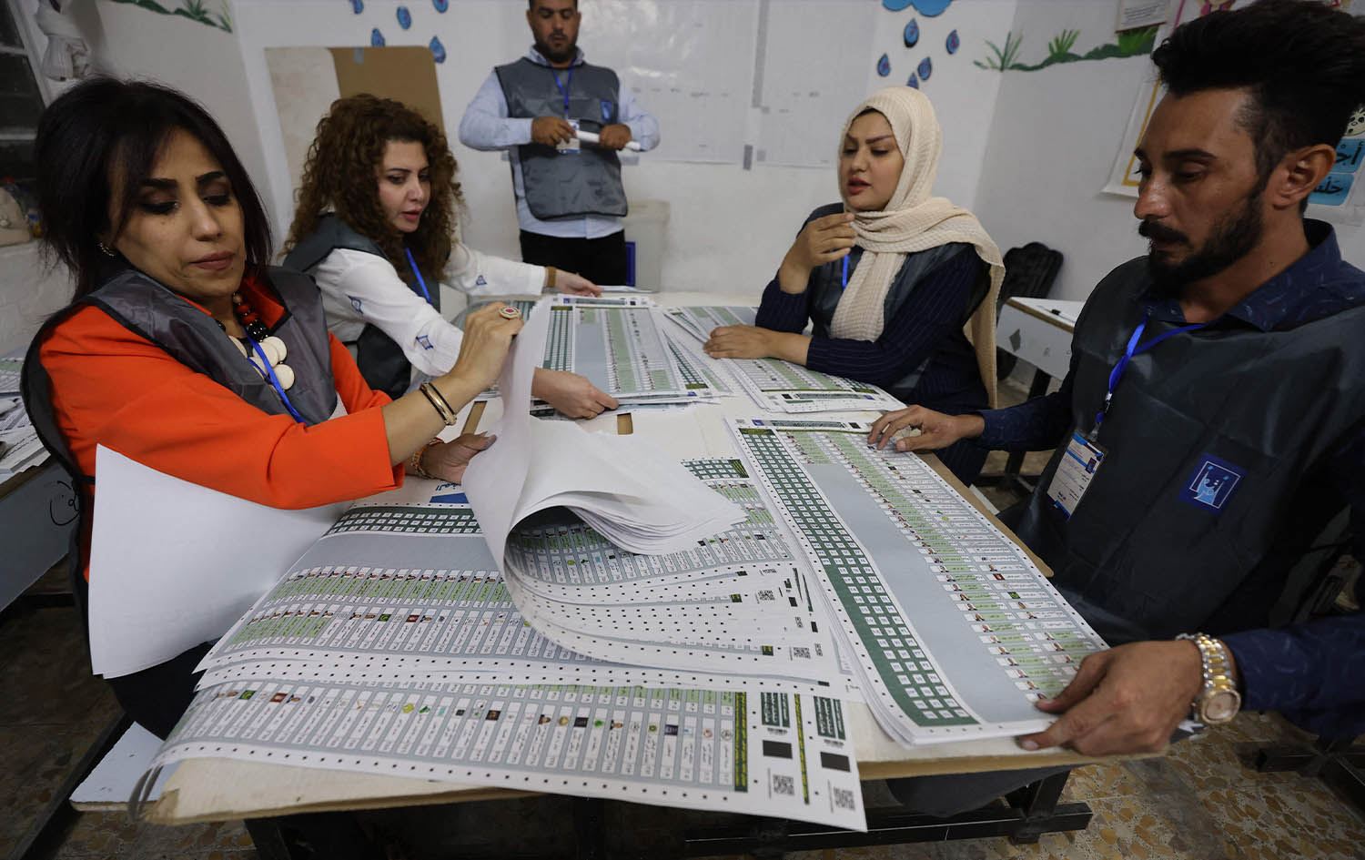 چەند کارمەندێکی کۆمیسیۆن لە بنکەیەکی دەنگدان لە بەغدا خەریکی جیاکردنەوەی دەنگی لایەنەکانن. وێنە: AFP