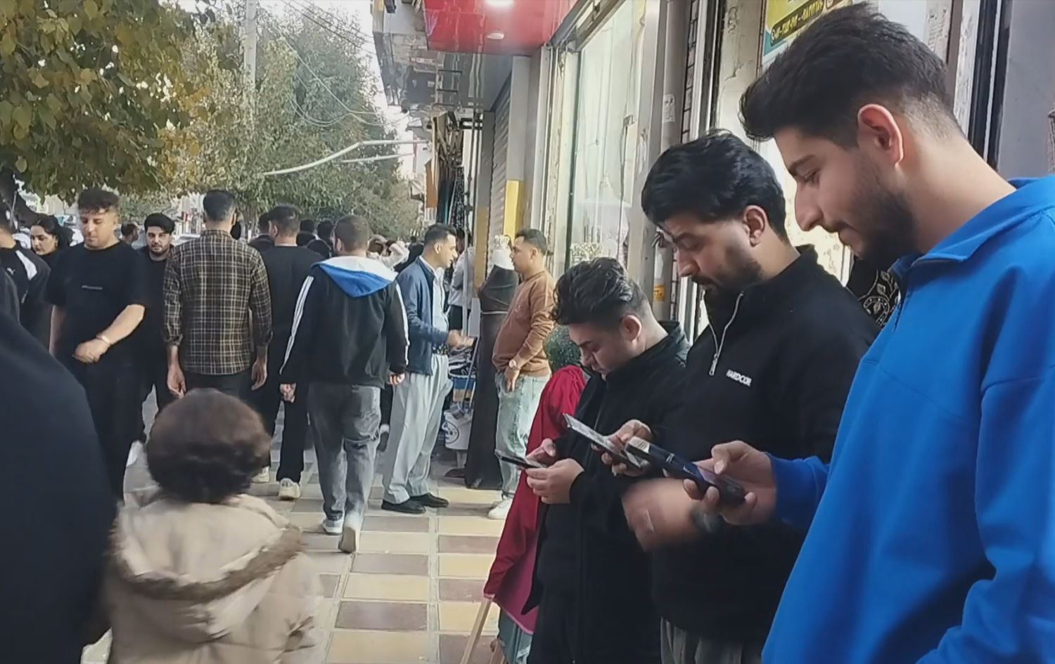 Residents using their phones in Kermanshah, Iran, in November. Photo: screengrab/Rudaw