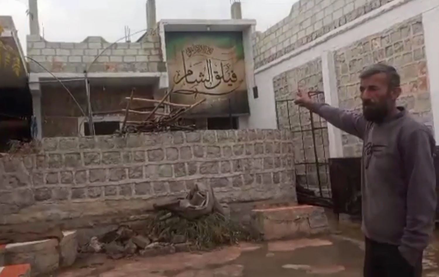 Feysel Husên Hebeş li ber mala xwe ya dagirkirî ye / Wêne: Ji vîdeoyê