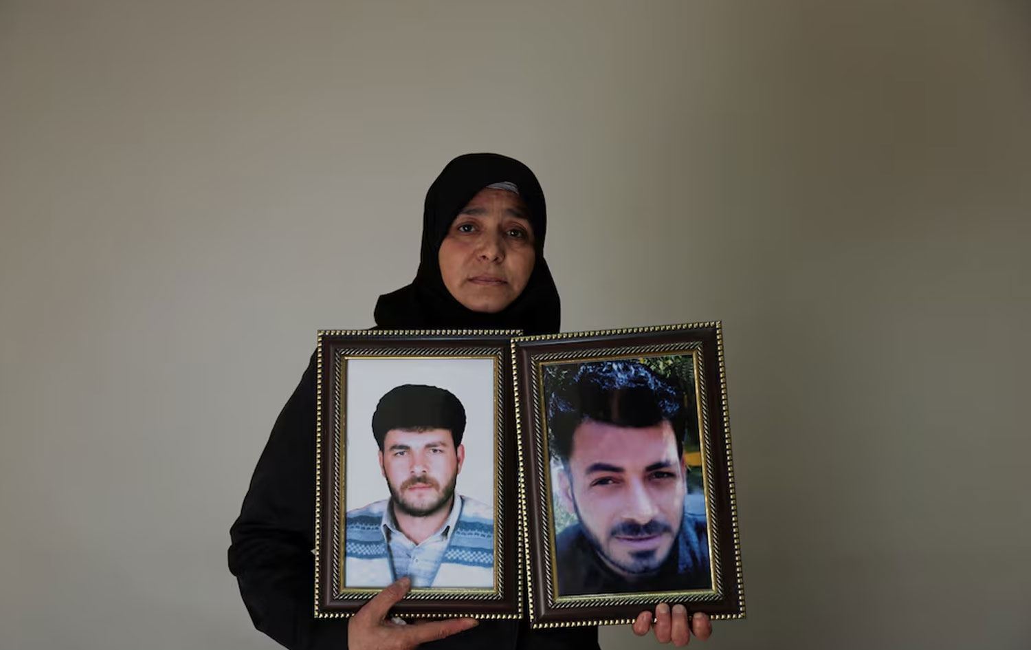 Amîna Beqayî wêneyê hevjîn û birayê xwe yên winda hildigire /Wêne: Reuters