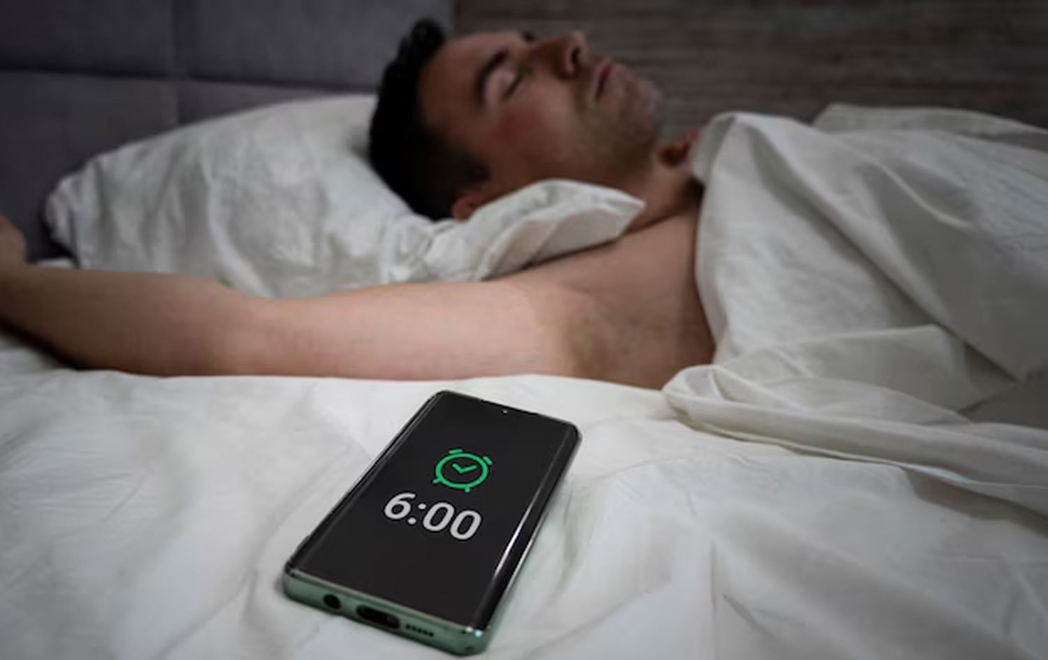 کەسێک لەژێر جێگەدا خەوتووە و مۆبایلەکەی خستووەتە سەر زەنگی ئاگادارکردنەوە. وێنەکە بۆ روونکردنەوەی هەواڵەکەیە