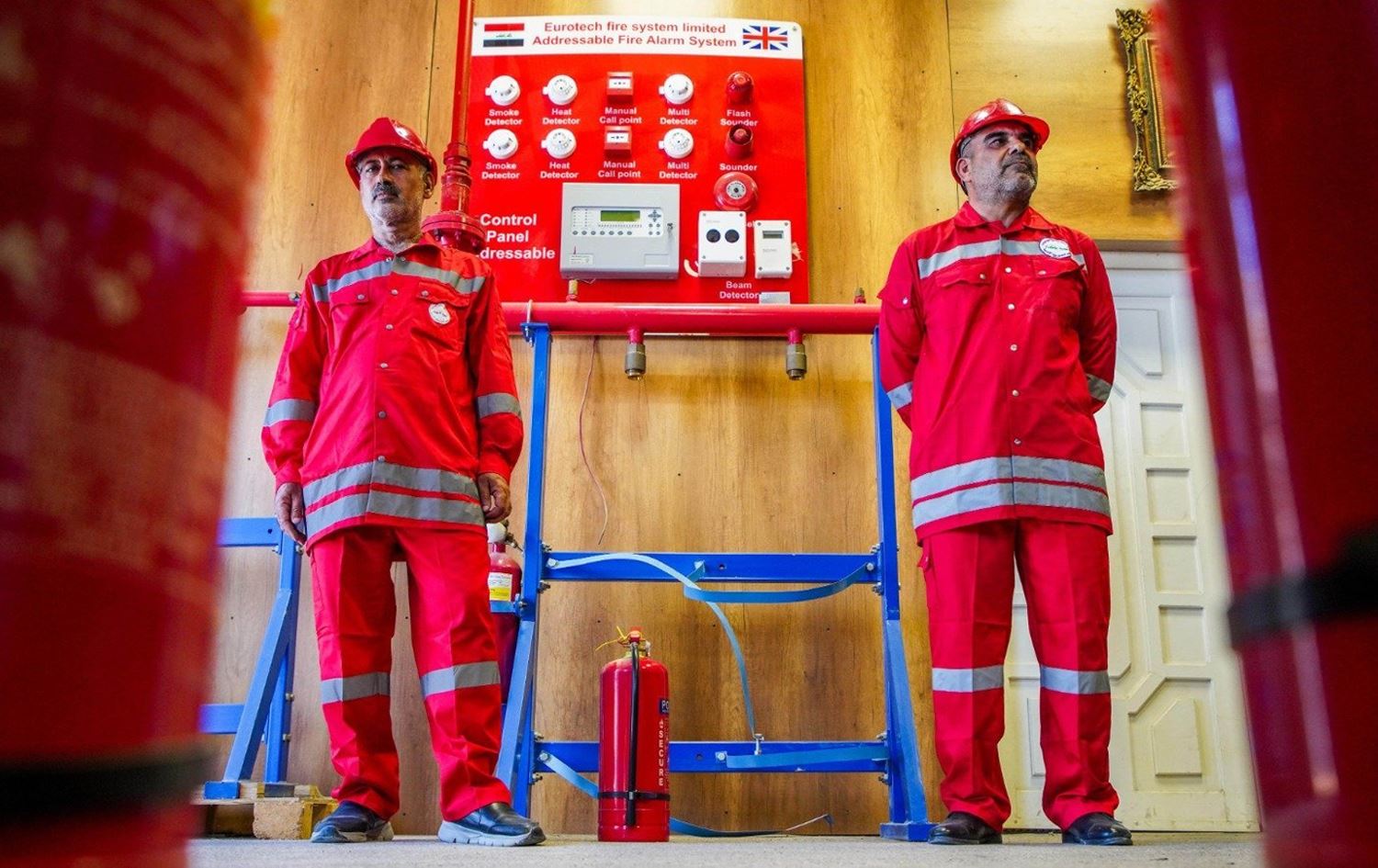 Firefighters standing in front of a fire alarm system. File photo: INA
