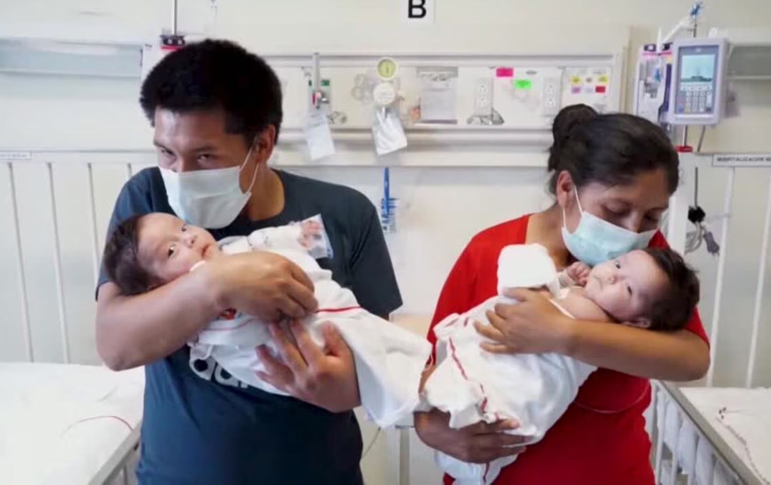 دووانەکە لەنێو باوەشی دایک و باوکیان. وێنە: Reuters