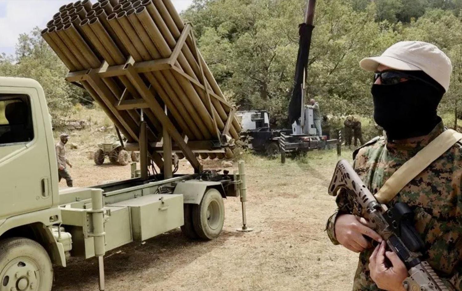 عنصر من الحزب يقف إلى جانب إحدى راجماته- صورة أرشيفية