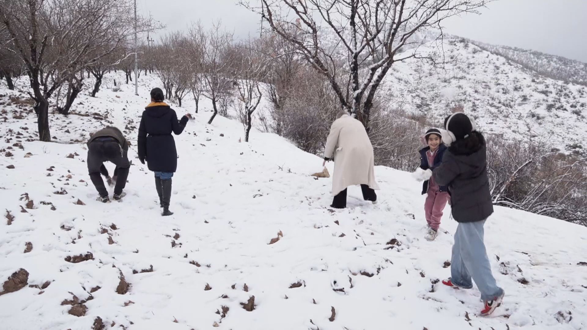 گەشتیاران لەنێو بەفر شەڕە تۆپەڵ دەکەن