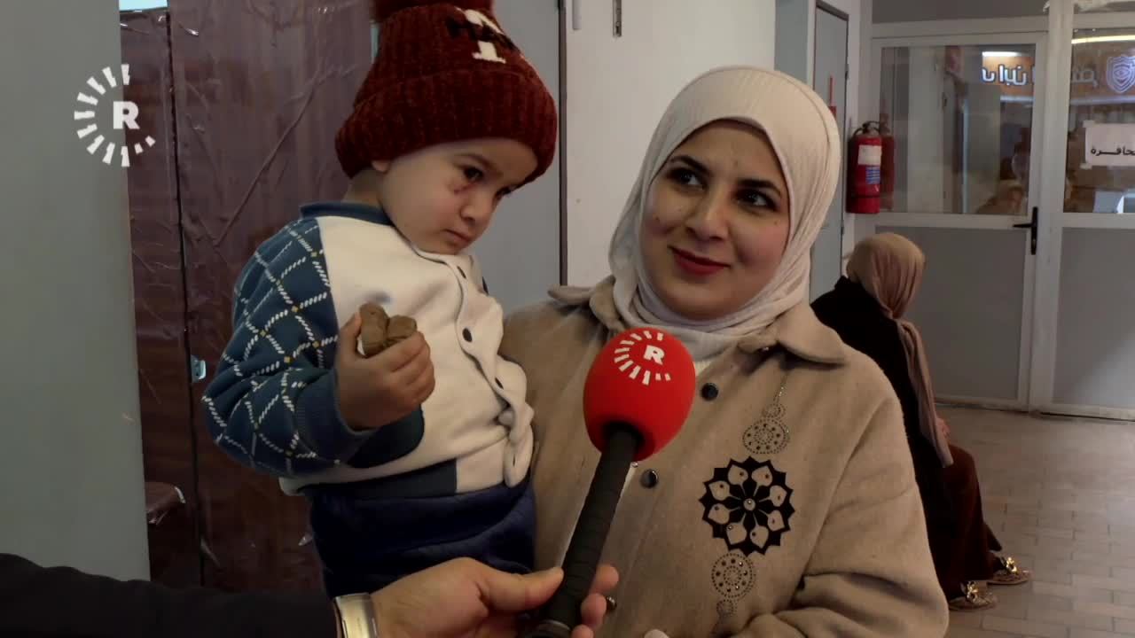 امرأة مع طفلها المصاب - رووداو 