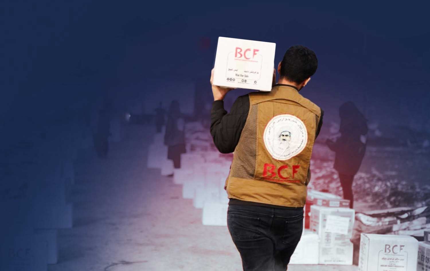 کەسێک بۆکسێکی هاوکاریی کە لۆگۆی دەزگای خێرخوازیی بارزانی پێوەیە، هەڵگرتووە