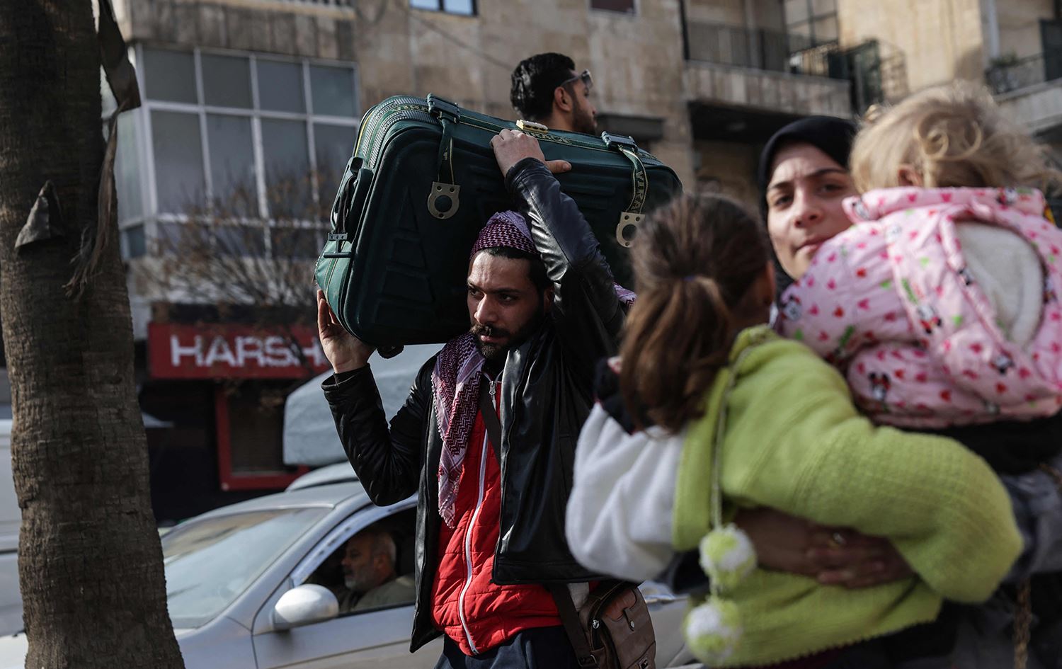 ئاوارەبوونی خێزانێک لە حەلەب بەهۆی هێرشی سوپای عەرەبیی سووریا بۆ سەر گەڕەکە کوردییەکانی شارەکە. وێنە: Bakr ALkasem / AFP
