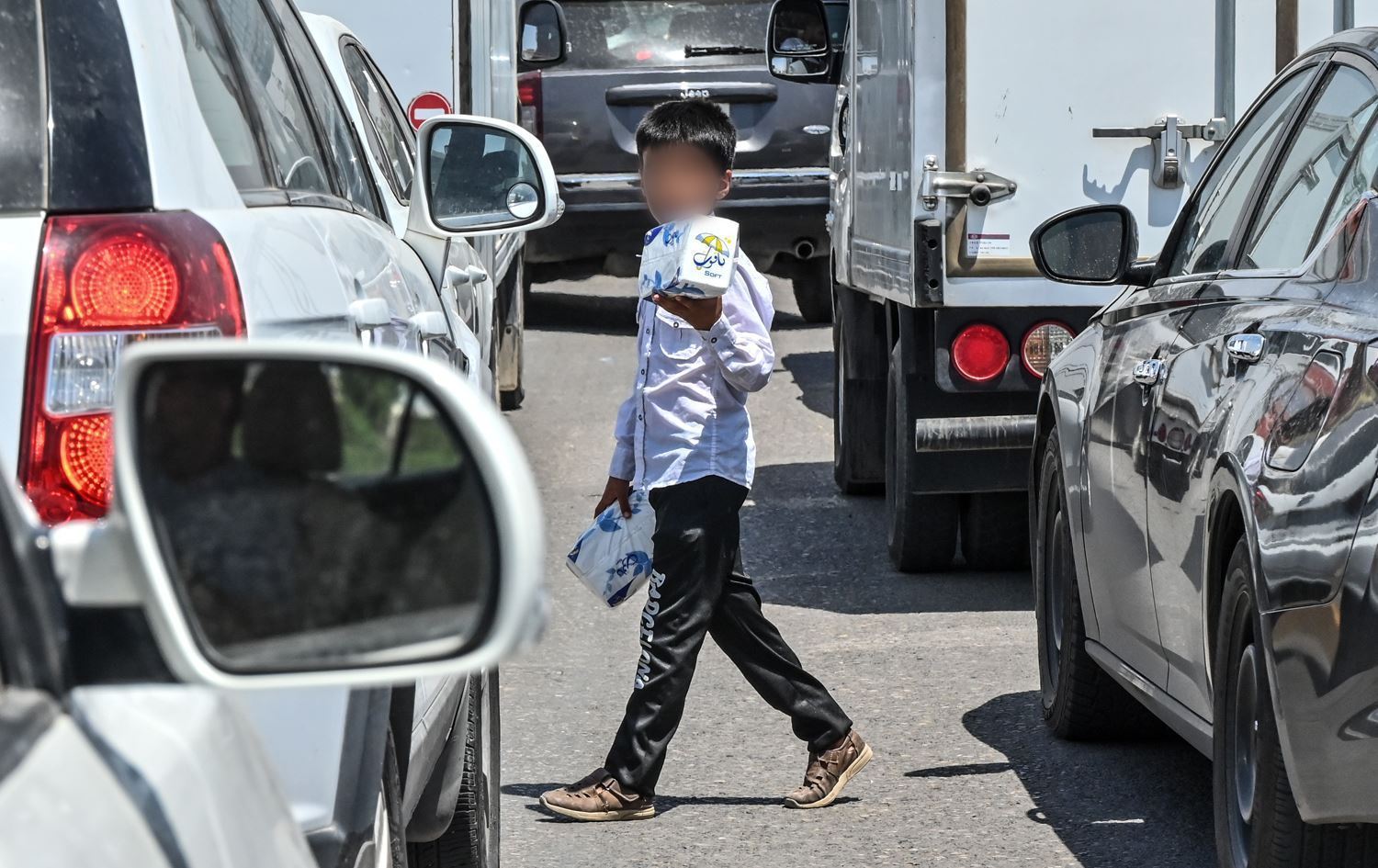 منداڵێک لە ترافیکلایتێکی هەولێر کلێنس دەفرۆشێت. وێنە: بڵند تاهیر - رووداو/ئەرشیڤ