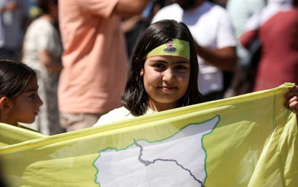 منداڵێک لە قامشلۆی رۆژاڤای کوردستان ئاڵا و سیمبولی هەسەدەی هەڵکردووە. وێنە: Reuters