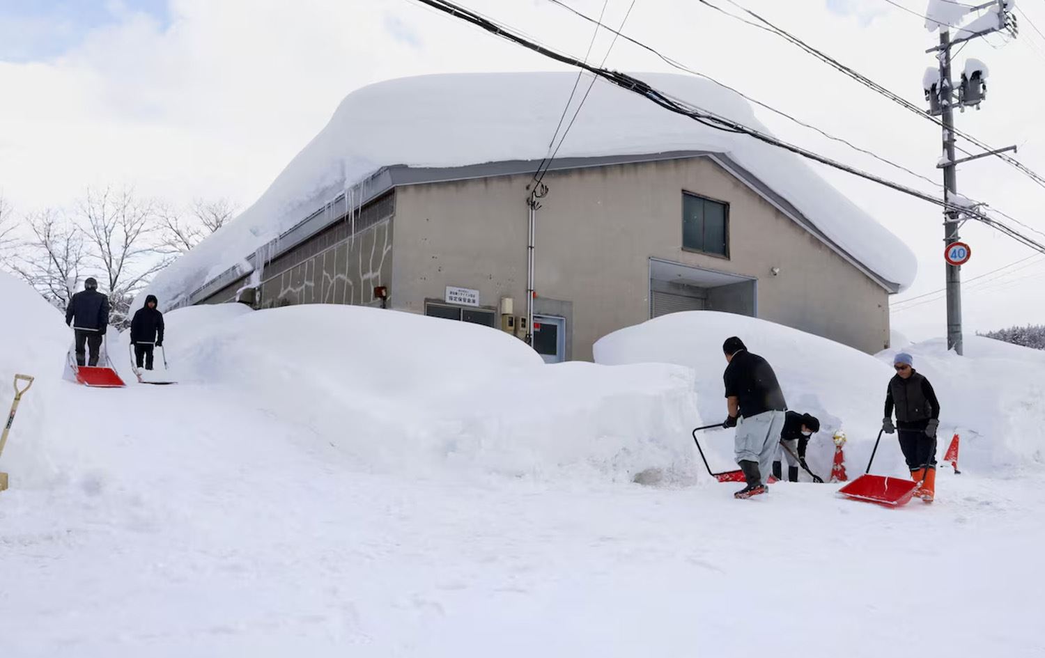 خەڵکی ناوچەیەکی شاری ئاۆمۆری لە باکووری رۆژهەڵاتی ژاپۆن بەفر دەماڵن. وێنە: REUTERS