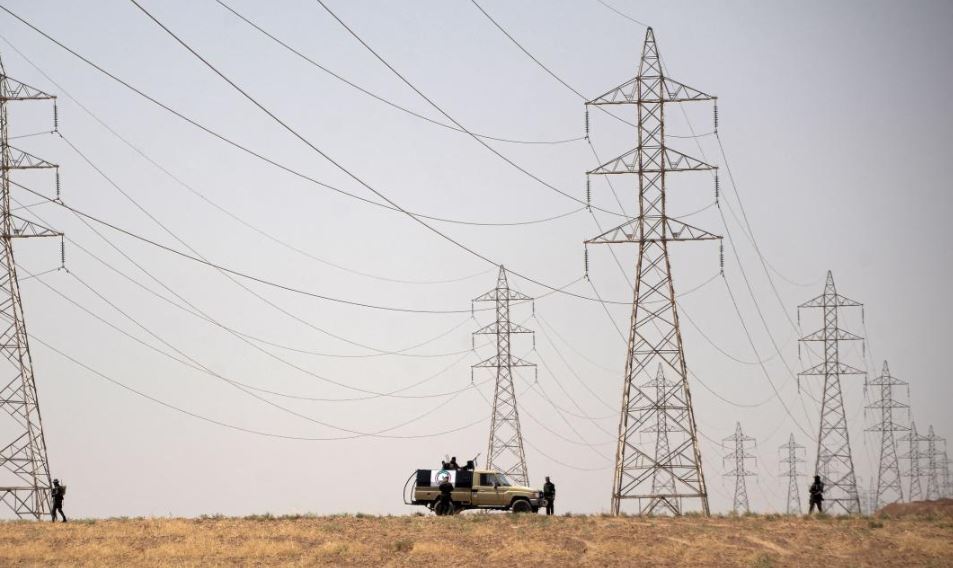 عناصر أمنية يحرسون خطوطاً لنقل الكهرباء- صورة أرشيفية