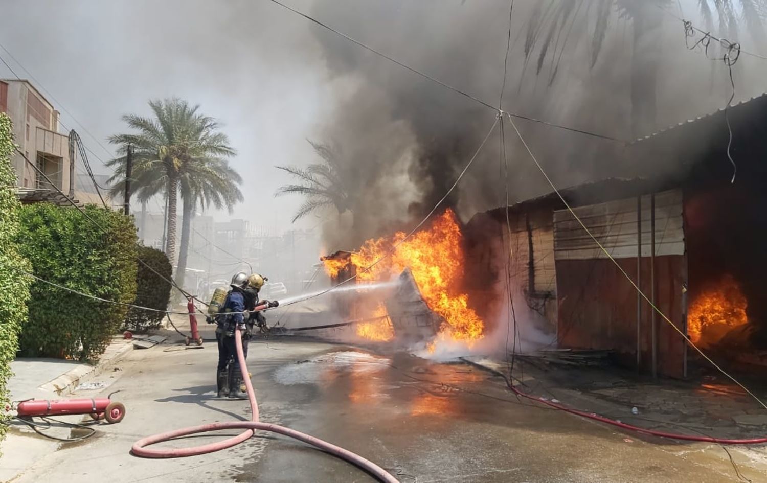 فريق من الدفاع المدني العراقي خلال اخماده حريقاً - ارشيف