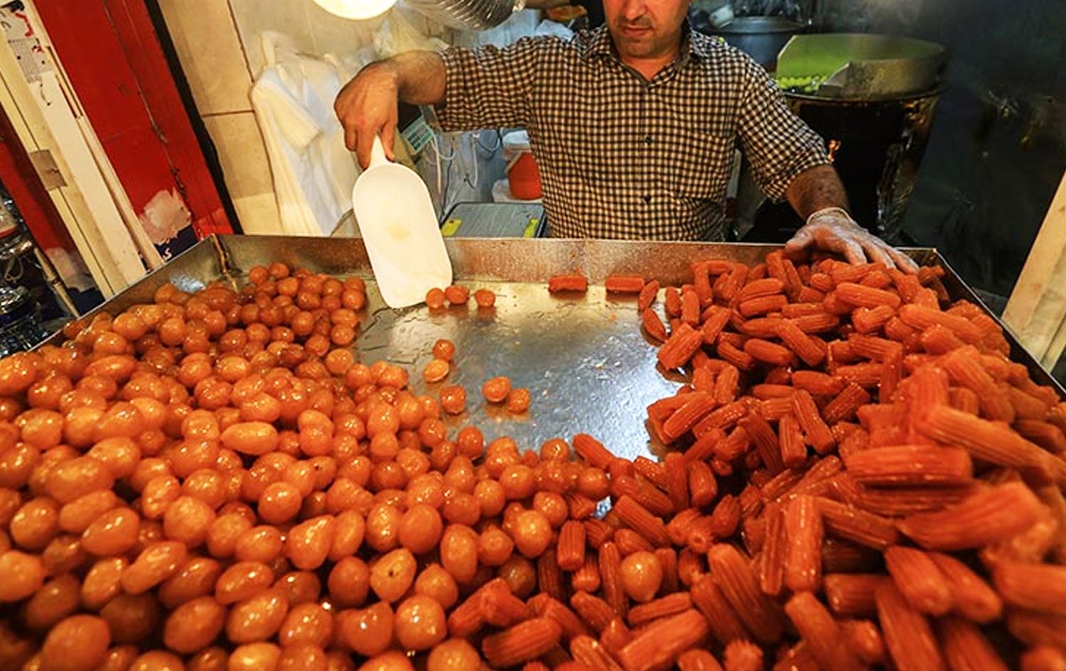 فرۆشیارێکی شیرینیی لوقمەقازی و بامیە.