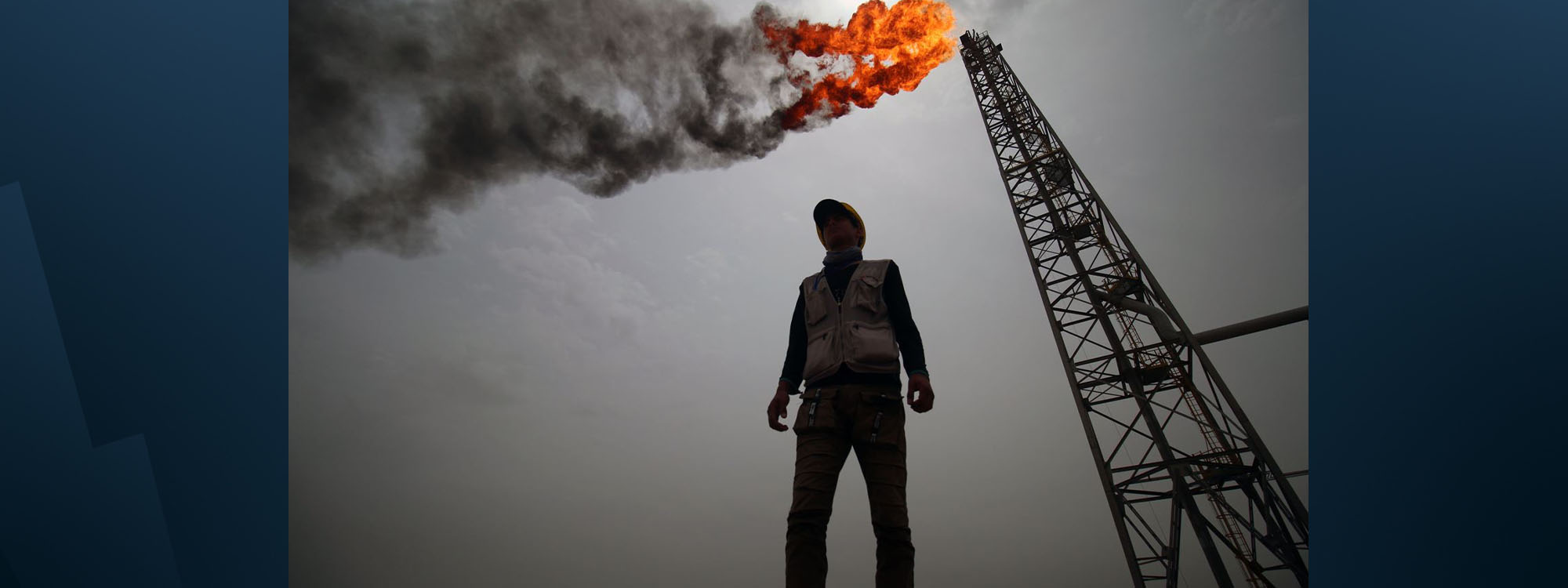 An oil worker stands in front of a derrick in Iraq. Photo: AFP