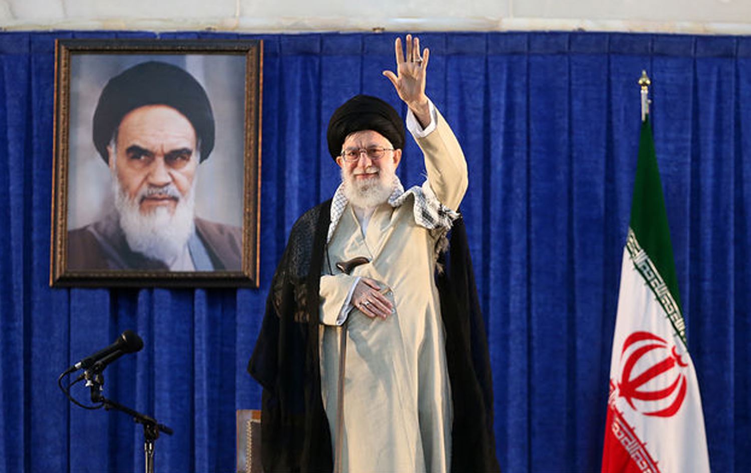 The late Iranian Supreme Leader Ayatollah Ali Khamenei, waving next to a portrait of his predecessor Ayatollah Ruhollah Khomeini during the 30th death anniversary of the latter at his shrine in Tehran on June 4, 2019. Photo: Khamenei.ir