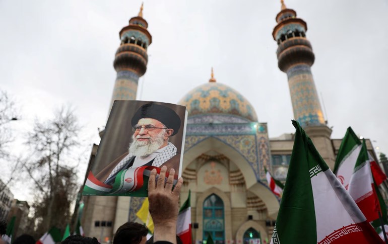   شیوەنگێڕیک وێنەی عەلی خامنەیی لە تاران بەرزکردووەتەوە دژی کوشتنی رێبەرەکەیان لەلایەن ئەمریکا و ئیسرائیلەوە. وێنە: Reuters