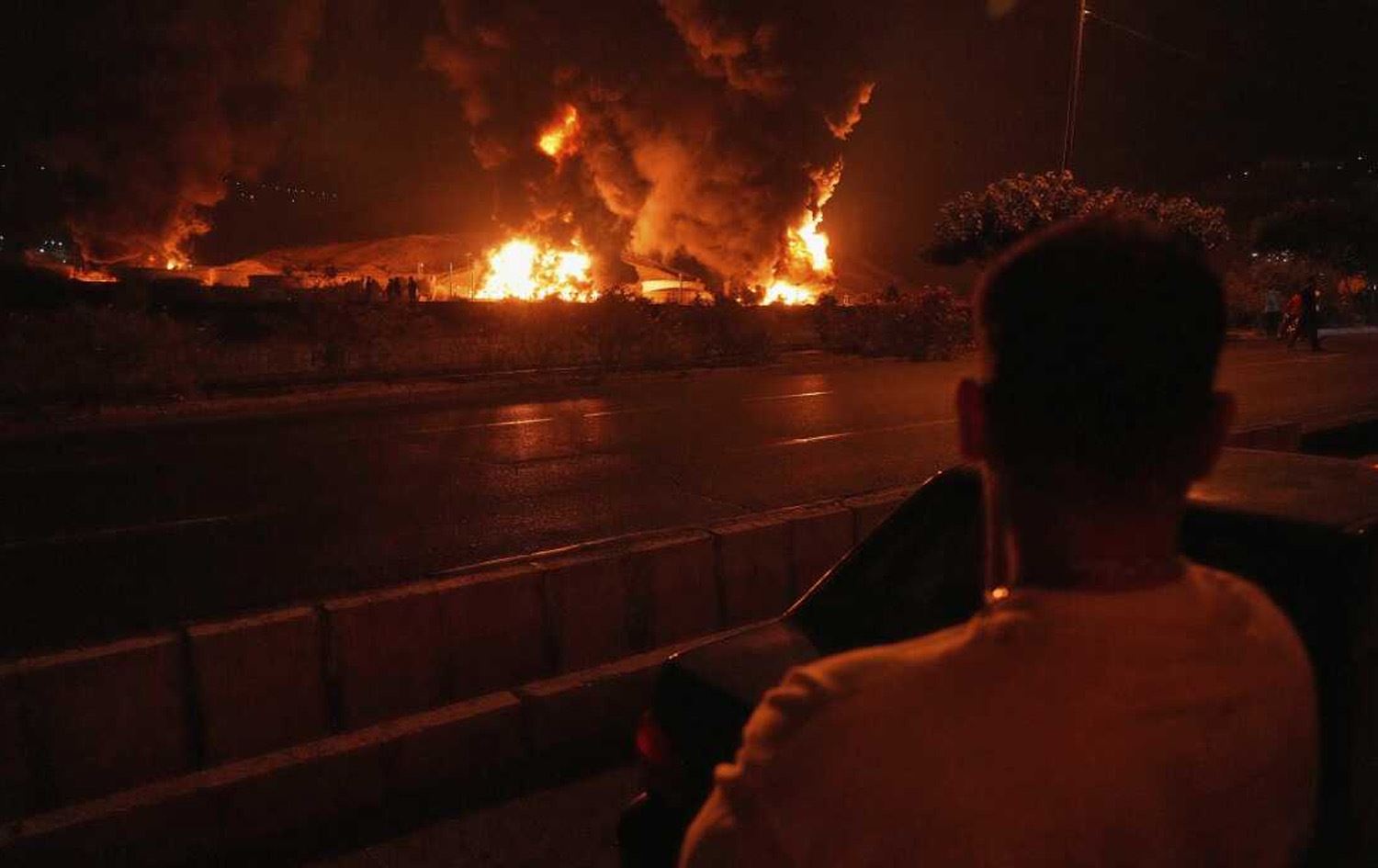 پیاوێک لە تاران سەیری دیمەنی دوای بۆردوومانێک دەکات