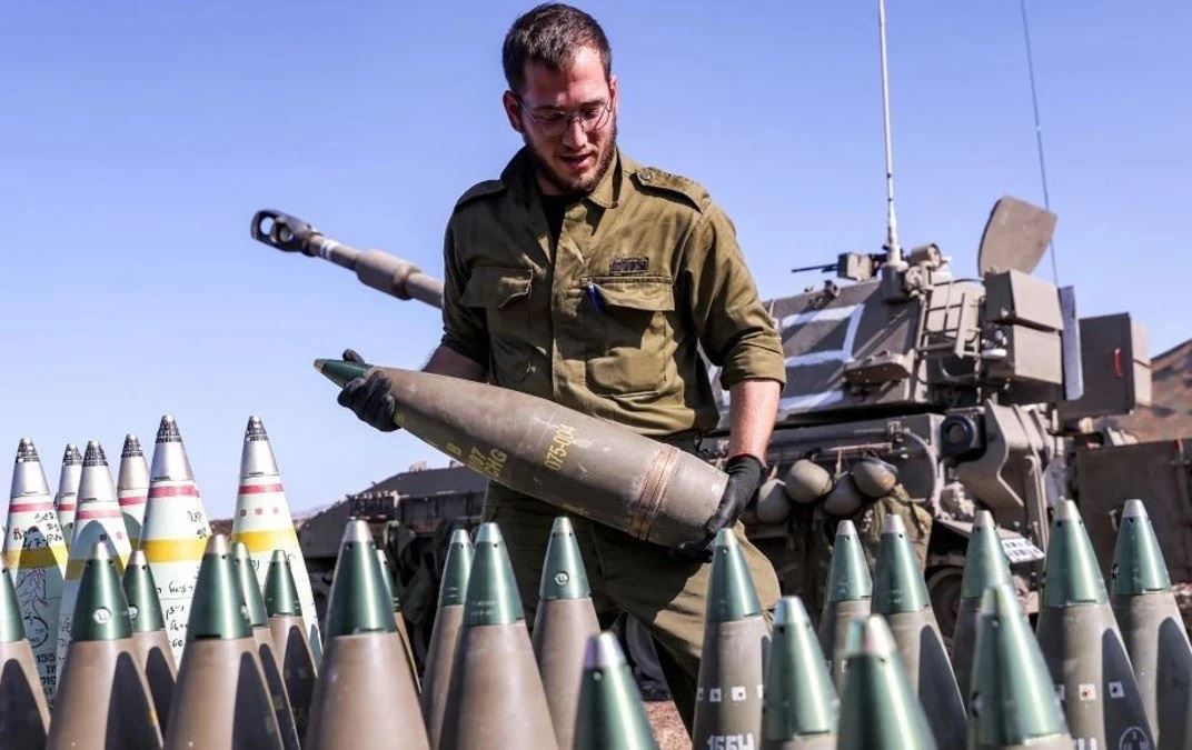 سەربازێکی ئیسرائیلی گوللە تۆپێکی هەڵگرتووە