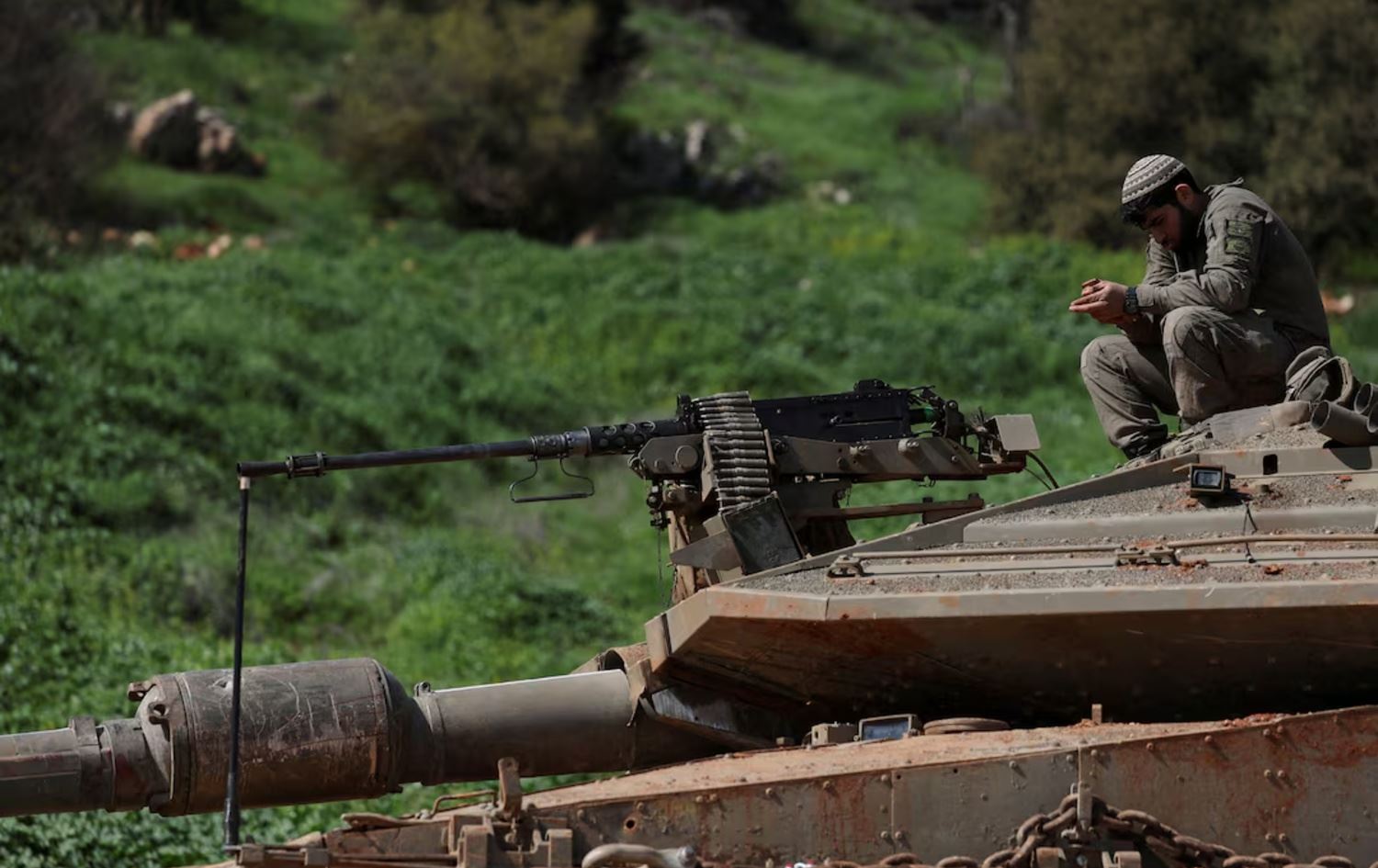 سەربازێکی ئیسرائیل لەسەر تانکێک دانیشتووە لەسەر سنووری لوبنان. وێنە: Reuters